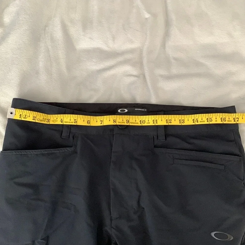 Oakley’s mens size 32 performance fit black athletic pants teal contrast back